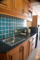 Compact kitchen with wooden cabinets and tiled backsplash