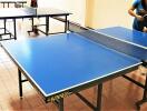 Two people playing table tennis in a recreational room