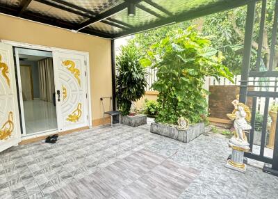 Outdoor covered balcony with plants and decorated doors