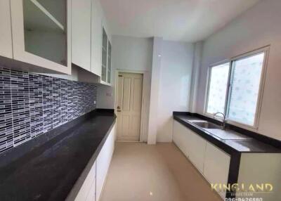 Modern kitchen with black countertops and tile backsplash