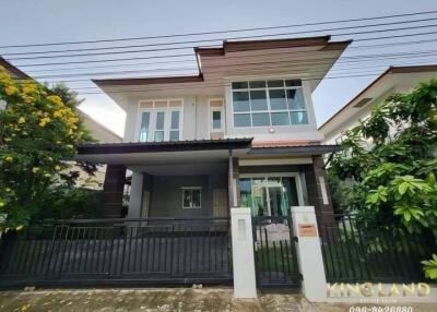 Modern two-story house with a garden and gated entrance