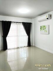 Living room with tile flooring, air conditioner, large window, and curtains