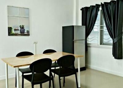 Modern dining area with table, chairs, and refrigerator