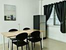 Modern dining area with table, chairs, and refrigerator