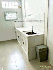 Simple white kitchen with countertop, sink, and cabinets