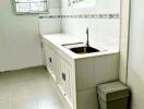 Simple white kitchen with countertop, sink, and cabinets