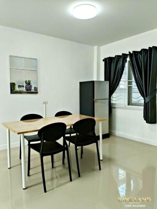 Dining room with table, four chairs, and refrigerator