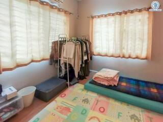 Well-lit bedroom with large windows and organized storage