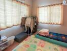 Well-lit bedroom with large windows and organized storage