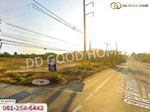 View of an empty plot of land beside the road with power lines