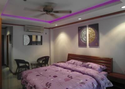 Modern bedroom with purple bedding and ambient lighting