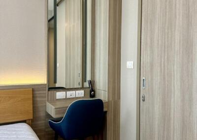 Bedroom with vanity area and blue chair