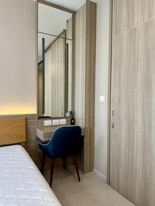 Bedroom with vanity area and blue chair