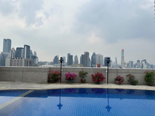 Rooftop area with a swimming pool and city skyline view