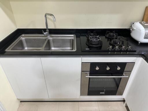 Modern kitchen with stainless steel sink and built-in oven