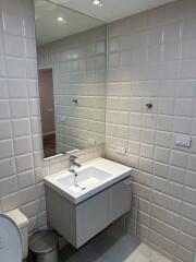 Modern bathroom with tiled walls and a large mirror