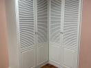 Corner with white louvered closet doors