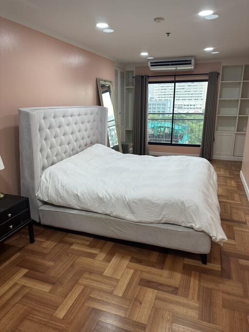 Cozy bedroom with elegant tufted headboard and parquet flooring