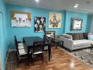 Living and dining area with teal walls, dining table, and couch