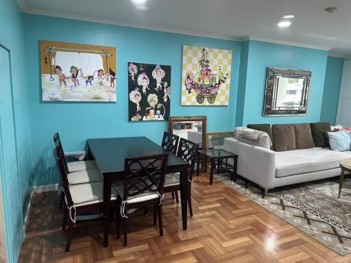 Living and dining area with teal walls, dining table, and couch