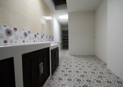 Modern kitchen with patterned floor tiles, built-in cabinets, and decorative backsplash