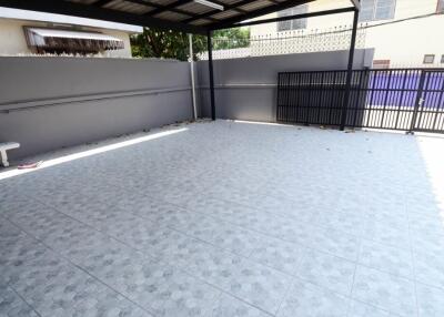 Spacious tiled outdoor area with a roof