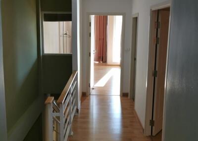 Bright hallway with wooden flooring and white walls