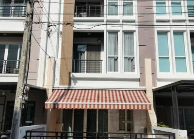 Front view of a multi-story residential building with gated entrance