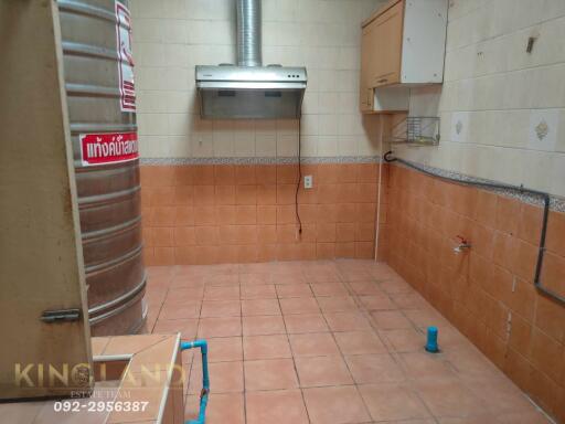 Simple kitchen area with exhaust hood and storage tank