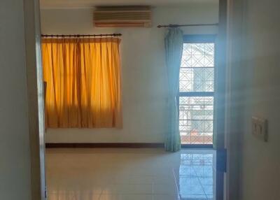 Bedroom with large window and yellow curtains