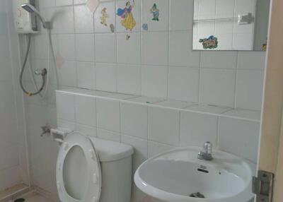 Bathroom with toilet, sink, shower, and decorative tiles