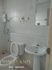 Bathroom with toilet, sink, shower, and decorative tiles