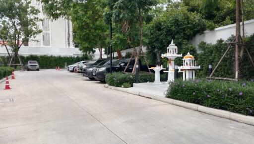 Parking area with several parked cars and greenery