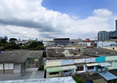 View of city rooftops and buildings under a cloudy sky