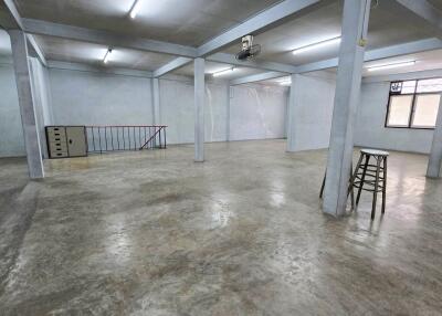 Spacious open area with concrete flooring and structural pillars