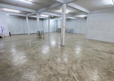 Empty spacious basement with concrete flooring and exposed beams