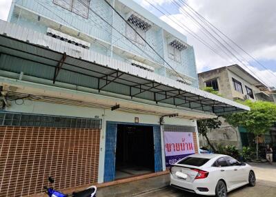 A two-story residential building with a covered carport.