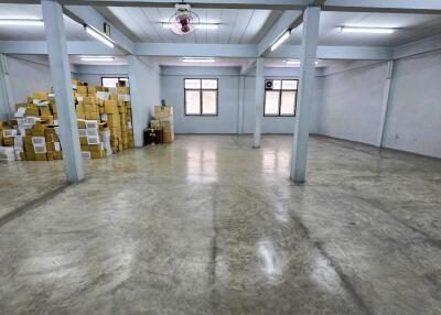 Spacious warehouse area with concrete flooring and stacked boxes