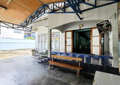 Covered outdoor area with seating and entrance to the house