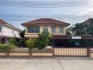 Two-story house with a fenced yard, driveway, and carport