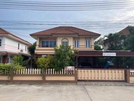 Two-story house with a fenced yard, driveway, and carport