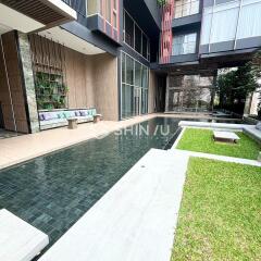 modern building entrance with outdoor seating and pool