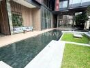 modern building entrance with outdoor seating and pool