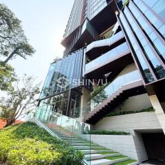 Modern high-rise building with glass exteriors and greenery