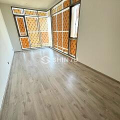 Spacious living room with large windows and wooden flooring