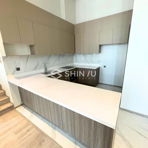 Modern kitchen with ample storage and marble countertops - Shinvu Real Estate