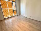 Empty bedroom with wooden floor and large window