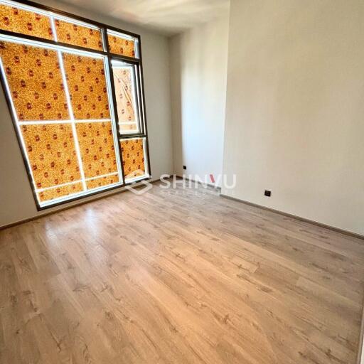 Empty bedroom with wooden floor and large window