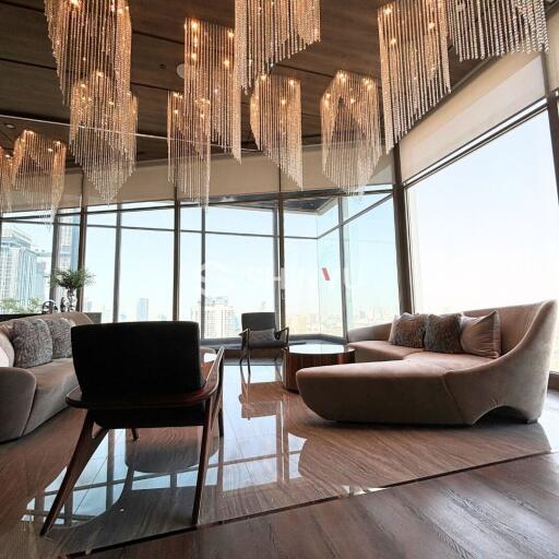 Spacious and luxurious living room with modern chandeliers and large windows