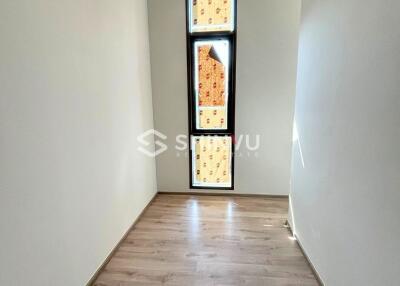 Small room with wooden flooring and tall window